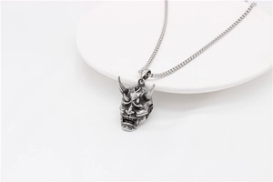 Detailed macro view of the intricate vintage silver Hannya skull pendant for men