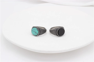 Macro view of vintage titanium steel rings with turquoise, black stone and scale texture