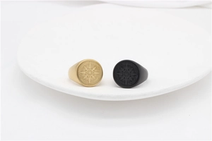 Detail of vintage compass rings in gold and black matte finish on a ceramic tray