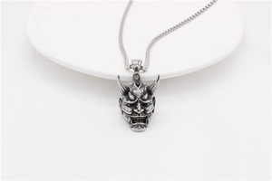 Detailed close-up of retro Hannya skull pendant on bead chain in vintage silver finish