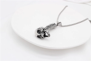 Detailed view of silver gothic skull and spine pendant necklace with classic chain