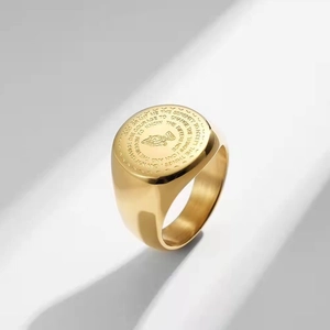 Detailed macro of golden Serenity Prayer ring with engraved praying hands icon