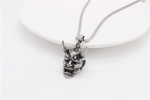 Detailed close-up of retro Hannya mask skull pendant with vintage steel finish