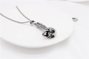 Macro view of gothic skull and spine pendant with vintage silver finish on white tray
