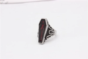 Macro shot of punk coffin ring featuring gothic red enamel inlay and intricate carvings
