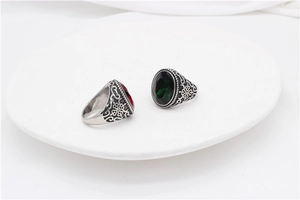 Detail showing vintage titanium steel rings with red and green gems and floral engravings