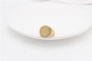 Macro detail of vintage gold compass signet ring with intricate star engraving