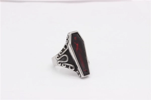 Detailed close-up of a gothic coffin ring with dark red inlay and skull relief