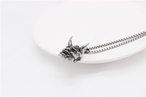 Detail of vintage silver Hannya skull pendant showing the textured dark metal finish