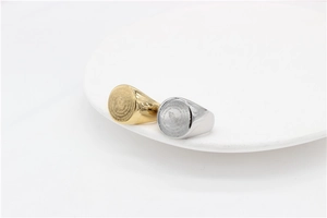 Macro shot of praying hands engraving and Serenity Prayer on gold and silver signet rings