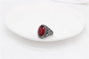Macro detail of vintage style titanium steel ring with a large oval red gemstone inlay