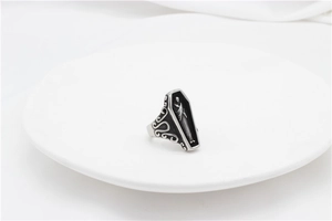 Macro view of gothic coffin ring with detailed reaper relief in vintage silver finish