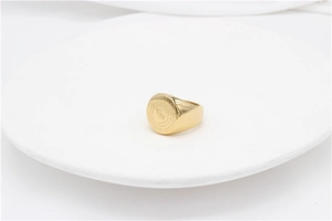 Detailed close-up of golden signet ring with praying hands and Serenity Prayer engraving