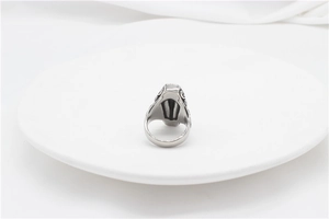 Detailed side view of vintage silver ring featuring ornate engraved scroll patterns on white
