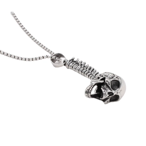 Gothic punk silver skull and spine pendant necklace with beaded metal chain on white background