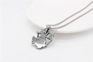 Detail view of vintage silver reaper scythe pendant with antique finish and steel chain
