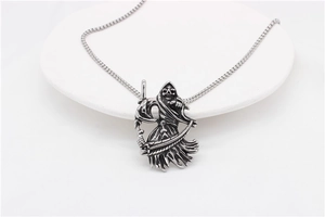 Macro shot of silver Grim Reaper pendant with scythe in vintage matte stainless steel