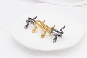 Macro detail of snake-shaped rings showing intricate scale textures and gem-set eyes