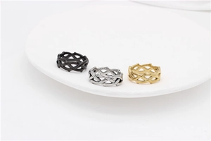 Three thorn crown rings in black silver and gold on a white ceramic display plate