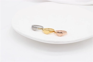 Three minimalist heart signet rings in silver, gold, and rose gold finishes on a white tray