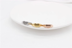 Detailed view of heart-shaped metal rings in silver, gold, and rose gold finishes