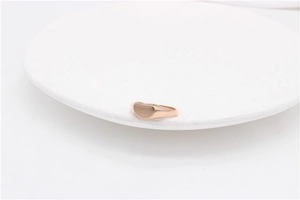 Macro view of a minimalist rose gold heart signet ring with a polished surface