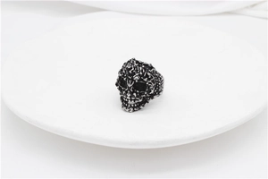 Detailed view of retro skull ring with intricate 3D embossed texture and punk style finish