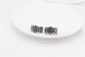 Close-up of vintage punk rings featuring intricate cross engravings and silver-gold finish