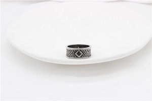 Macro detail of retro S925 silver ring featuring black gemstone and woven texture