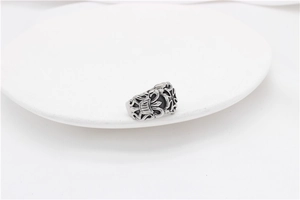 Detailed close-up of retro punk style wide band ring with gothic cross and fleur-de-lis