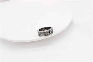Macro shot of silver woven texture band with black rhombus gemstone for men