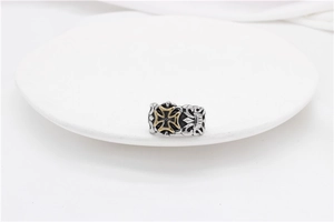 Macro shot of punk rocker vintage steel ring with golden cross and hollowed design