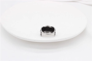 Detail view of vintage silver punk cross ring with crown-style embossed textures