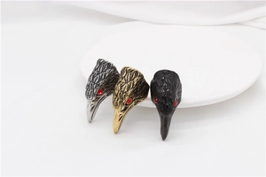 Detailed relief of eagle head rings with red gemstone eyes in silver, gold and black