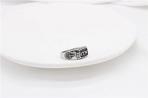 Close-up of vintage steel ring with FTW lettering and embossed skeletal hand details
