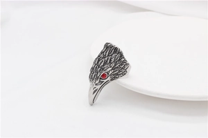Detailed view of vintage steel eagle ring featuring feather texture and red stone eye