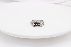 Detailed macro view of silver vintage FTW engraved ring with flame relief details