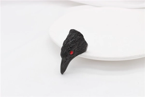 Macro detail of gothic eagle head ring with matte black texture and red zircon eye