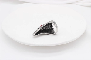 Detailed side view of vintage eagle ring with red gemstones and oxidized steel finish