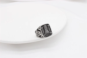 Detailed macro of vintage Masonic ring with engraved square, compass, and skull texture