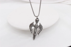 Detailed view of vintage silver steel trident pendant with intricate gothic engravings