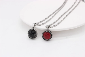 Close-up of vintage round gemstone pendants in red and black with silver chain