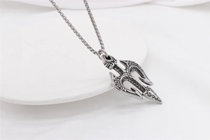 Macro shot of silver trident pendant with gothic engravings on a box chain necklace