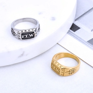 Retro FTW signet rings in gold and silver steel with vajra relief on marble display