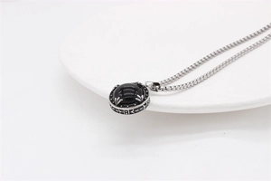 Macro view of vintage round stainless steel pendant necklace with black gemstone inlay