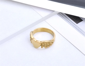 Detailed view of gold angel wings heart ring with polished finish and feather textures