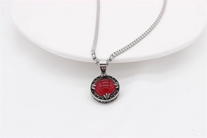 Detailed macro view of vintage round red gemstone pendant on a silver box chain