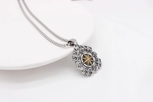 Macro view of vintage compass pendant in silver and gold with intricate engravings