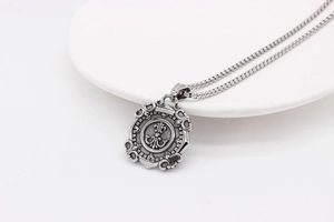 Macro shot of retro nautical compass shield pendant with oxidized steel chain detail
