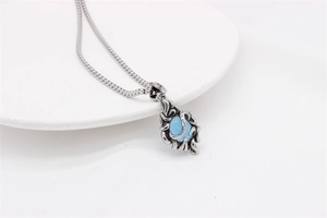 Macro detail of gothic vintage pendant featuring blue gemstone and intricate filigree